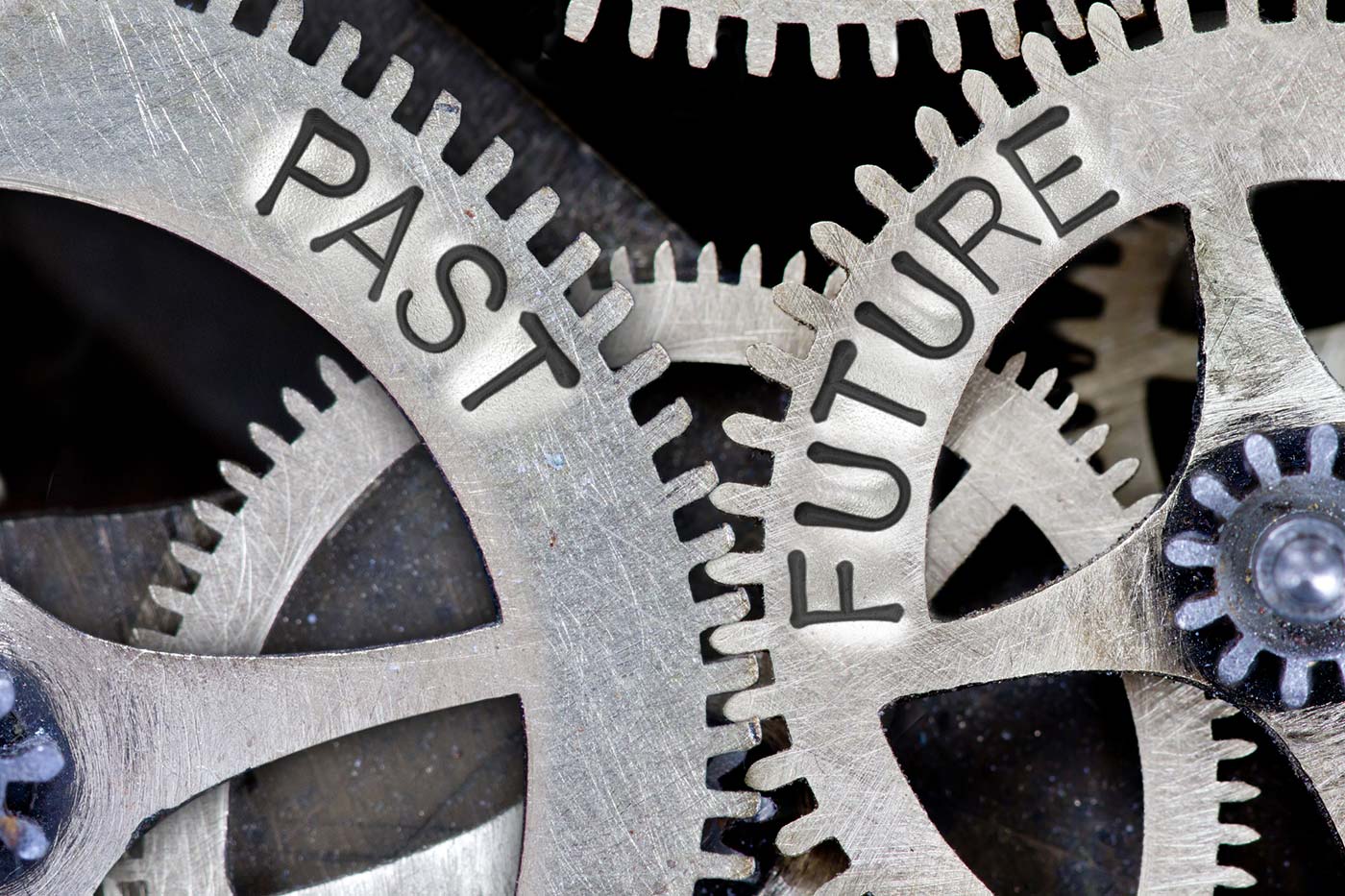 Photo of gears with the words past and future etched into them.